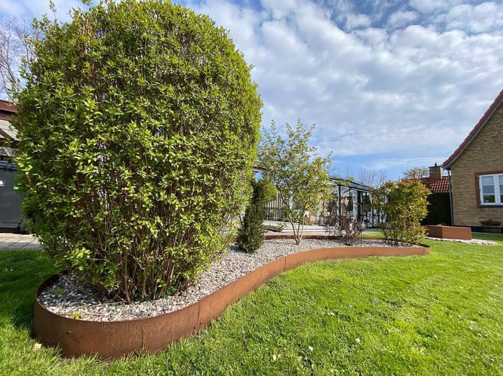 Geschwungene Beetumrandung aus Cortenstahl im Rasen – flexible Gartenkante in moderner Rostoptik