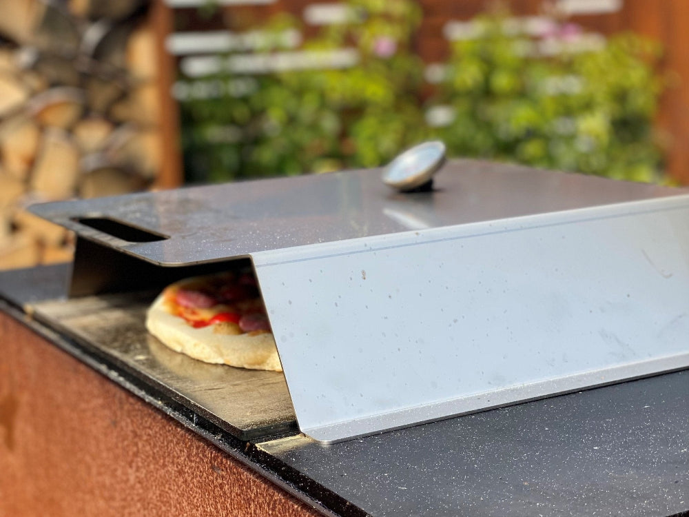 Pizzaofen aus Edelstahl auf der Grillplatte platziert