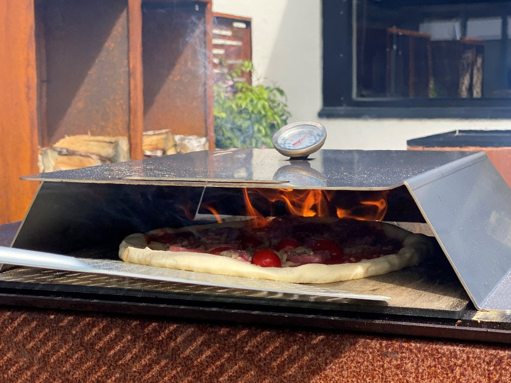 Pizzaofen im Einsatz auf dem Feuergrill mit Pizza