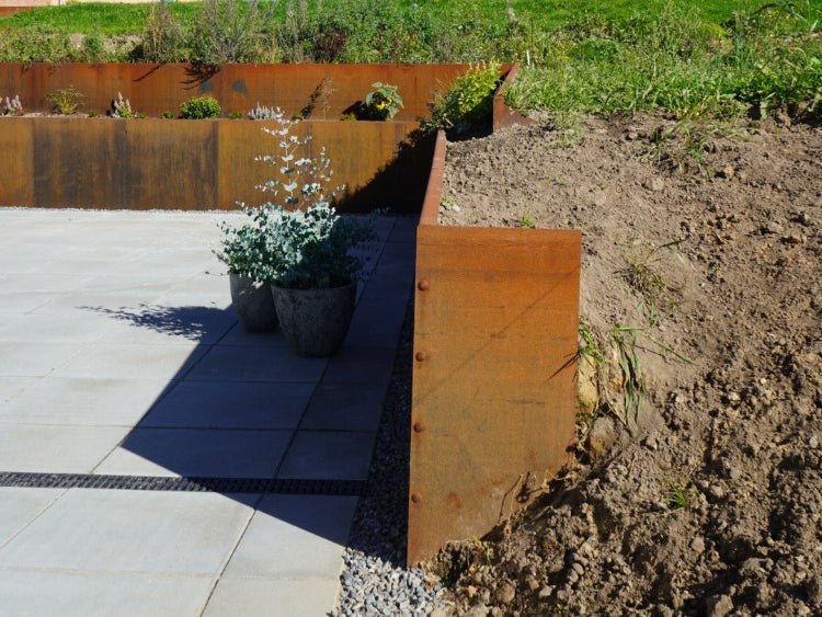 Endplatte für Stützmauer aus Cortenstahl im Gartenbeet