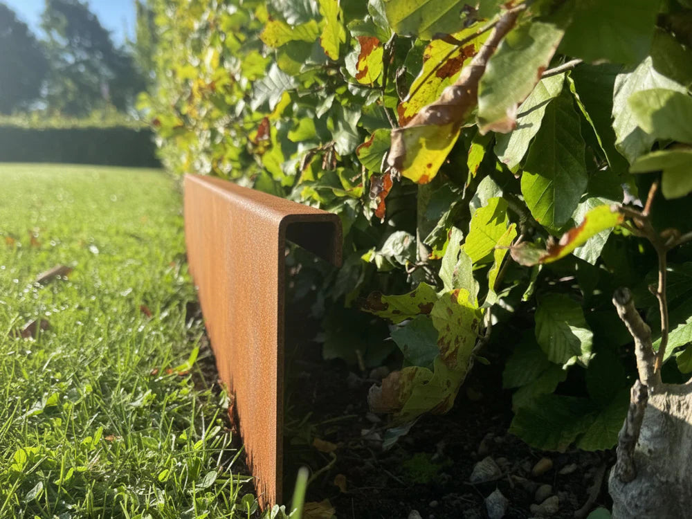 Detail einer Beetkante aus Cortenstahl mit Doppelumbug von byJEMA als langlebige Rasenkante im Garten