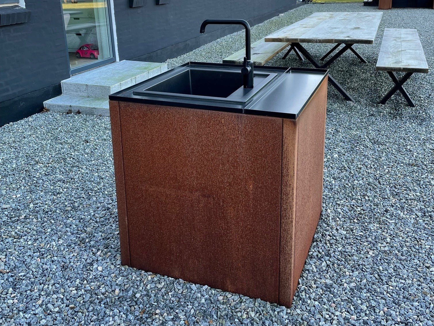 Freistehendes Waschmodul für Außenküche aus Cortenstahl mit schwarzer Arbeitsplatte