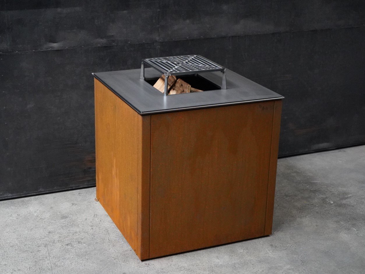 byJEMA Feuerstelle aus Cortenstahl mit schwarzer Stahlplatte und erhöhtem Grillrost – modernes Outdoor-Feuerelement im minimalistischen Design