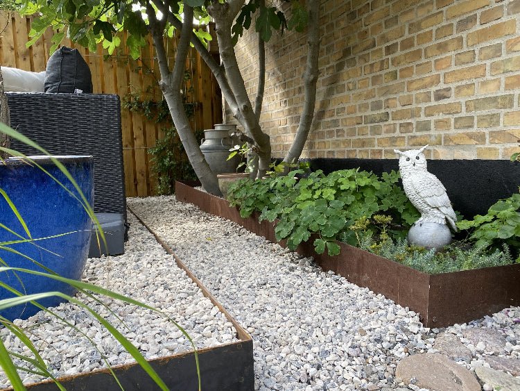 Eckdetail einer Beeteinfassung aus Cortenstahl neben Naturstein – witterungsbeständige Gartenkante