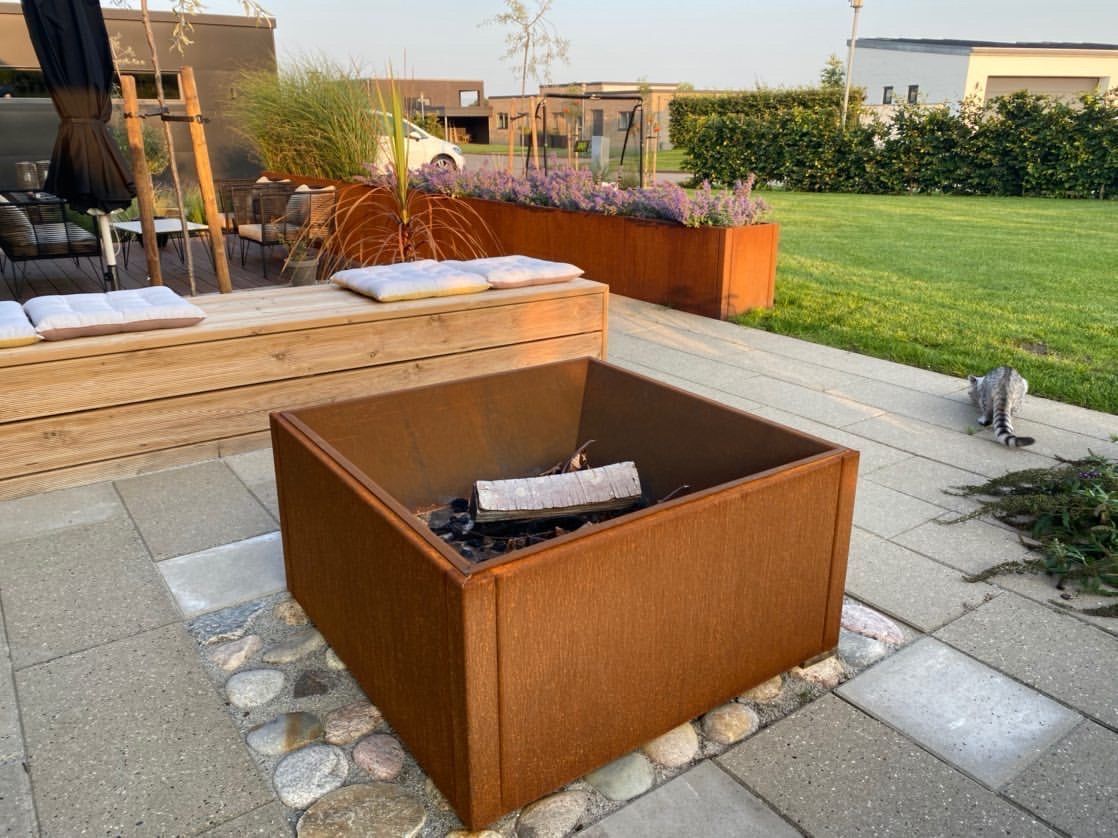 Quadratische Feuerstelle aus Cortenstahl auf moderner Terrasse im Garten – unbeheizt