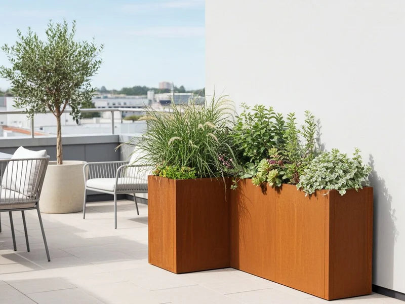 CUBY Winkel-Pflanzkasten aus Cortenstahl mit üppigen Pflanzen auf moderner Dachterrasse