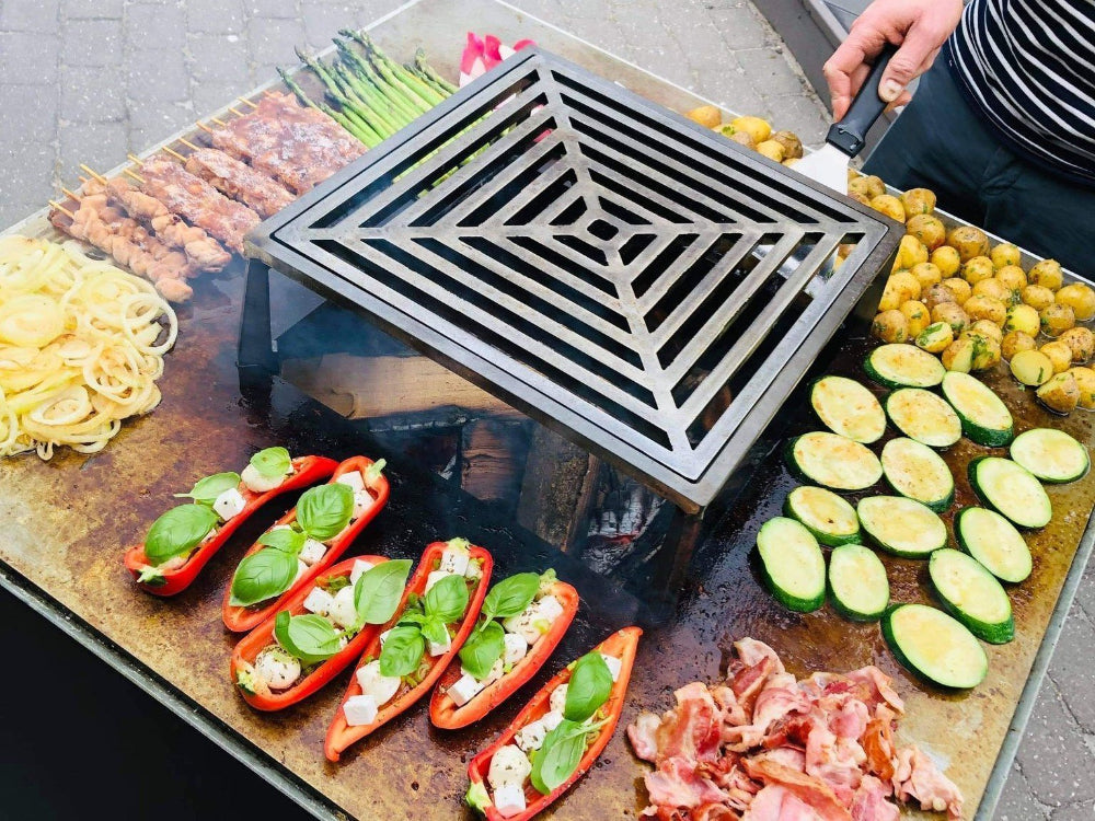 CUBY Feuergrill aus schwarz lackiertem Stahl mit Grillrost und Zubereitung von Gemüse und Fleisch