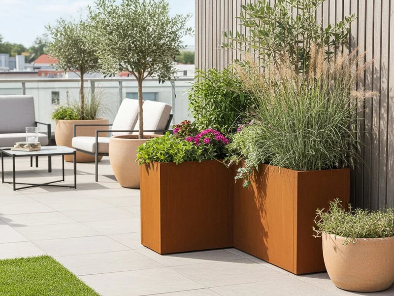 CUBY Winkel-Pflanzkasten aus Cortenstahl mit Blumen und Ziergras auf moderner Dachterrasse