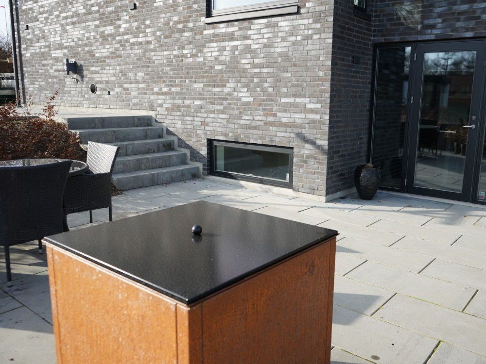 Deckel für Feuergrill aus schwarzem Stahl auf der Terrasse