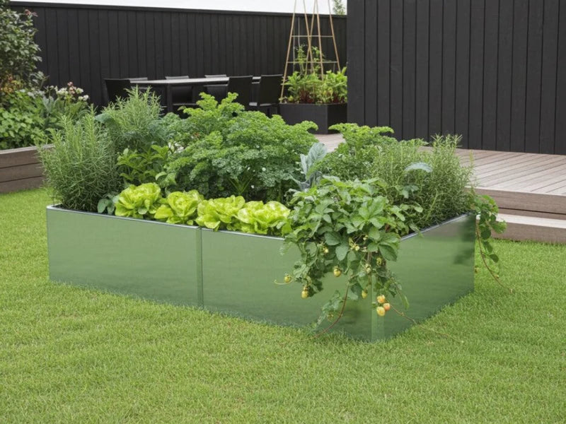 EDGY Hochbeet aus verzinktem Stahl mit dichter Bepflanzung an dunkler Holzfassade