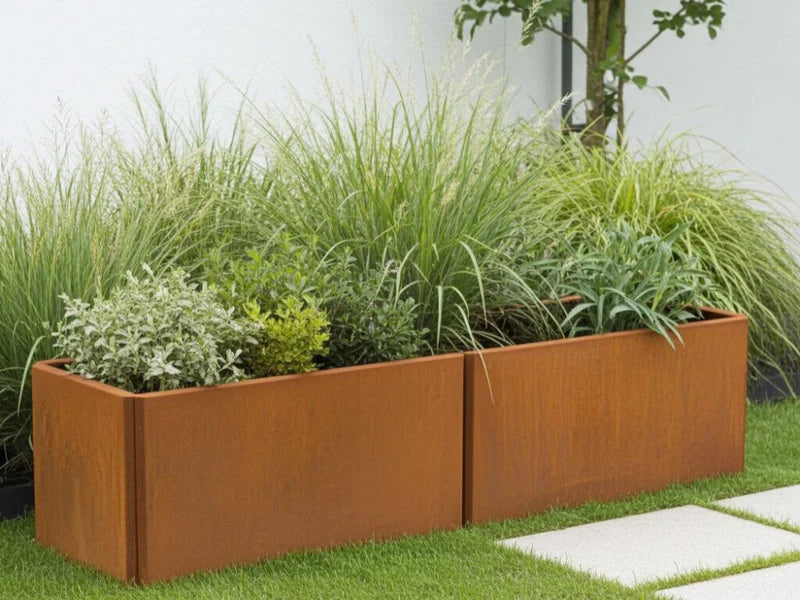 EDGY niedriger rechteckiger Pflanzkübel aus Cortenstahl mit Ziergräsern im Garten