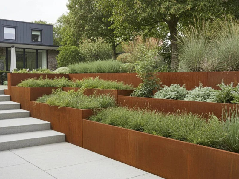 Terrassierte Stützmauer aus Cortenstahl mit Stauden im Garten